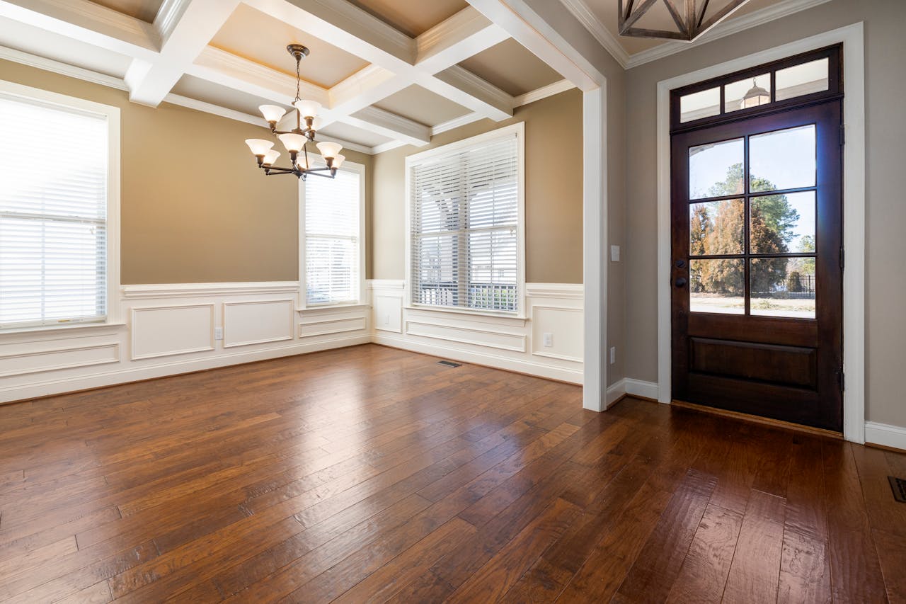 The Art of Drawing Readers In: Your attractive post title goes here Spacious empty living room with wooden flooring, large windows, and ceiling lights.